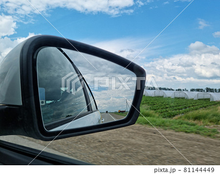 side mirror. shooting from passenger seat. travel along the road along fields. side mirror. shooting from passenger seat. travel along the road along fields. 81144449
