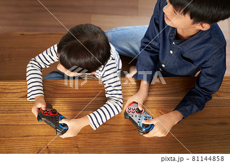 ゲームパッドを持つ男の子の手元 81144858