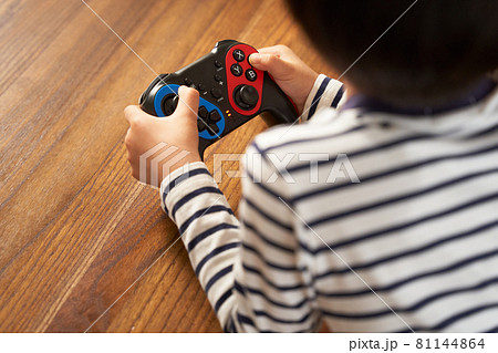 ゲームパッドを持つ男の子の手元 81144864