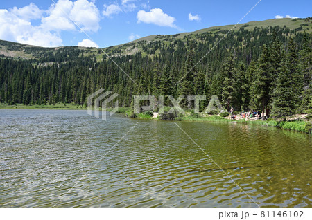 Distant hikers on shore of Hassell Lake in Arapaho National Forest, Colorado. Distant hikers on shore of Hassell Lake in Arapaho National Forest, Colorado. 81146102