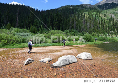 Hikers in shallow water on Hassell Lake Trail in Arapaho Nat'l Forest, Colorado. Hikers in shallow water on Hassell Lake Trail in Arapaho Nat'l Forest, Colorado. 81146558