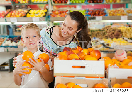 mother with little boy buying oranges at store 81148083