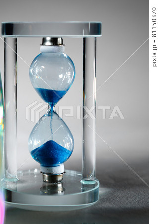 Blue hourglass on gray background close up 81150370
