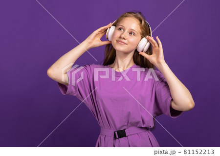 Half-length portrait of young beautiful smiling girl isolated on purple studio background. Concept of human emotions, facial expression, youth, sales, ad. Half-length portrait of young beautiful smiling girl isolated on purple studio background. Concept of human emotions, facial expression, youth, sales, ad. 81152213