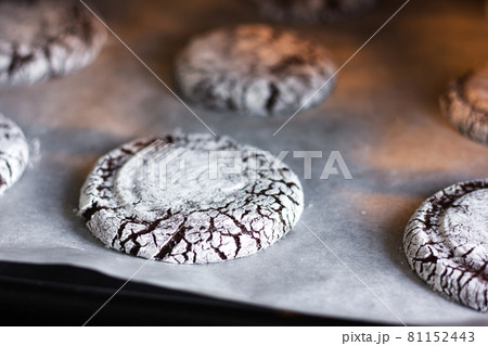 Batch of chocolate crinkle cookies on a parchment paper. Batch of chocolate crinkle cookies on a parchment paper. 81152443