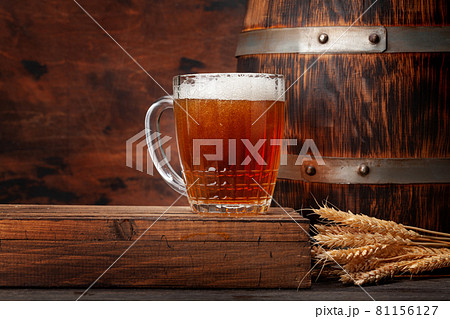 Mug of light lager beer and old wooden barrel 81156127