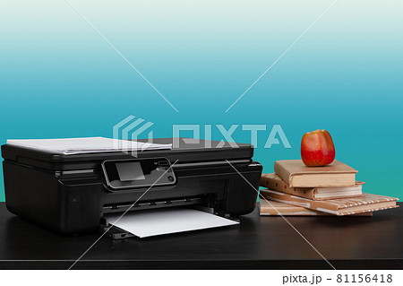 Home laser printer on desk against green background 81156418