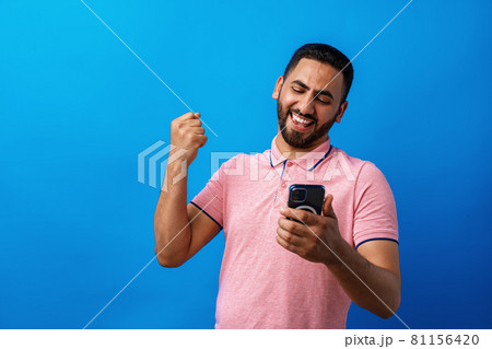 Portrait of arab man using his smartphone in studio 81156420