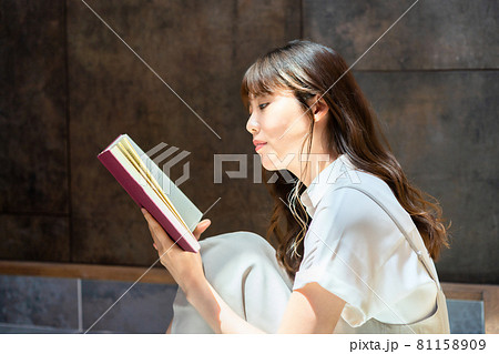 日差しがさしこむ部屋で読書をする女性 81158909
