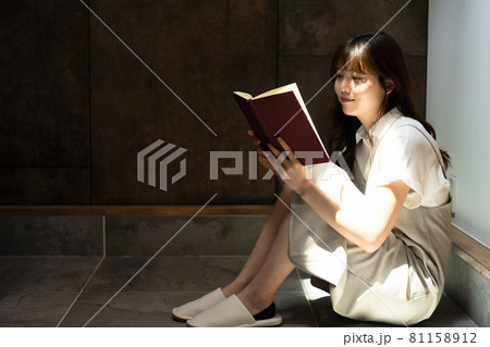 日差しがさしこむ部屋で読書をする女性 日差しがさしこむ部屋で読書をする女性 81158912