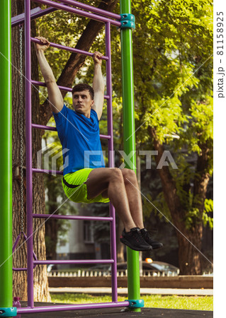 One young handsome caucasian man in sportswear training, exercising on sports ground outdoors on bright summer day. One young handsome caucasian man in sportswear training, exercising on sports ground outdoors on bright summer day. 81158925