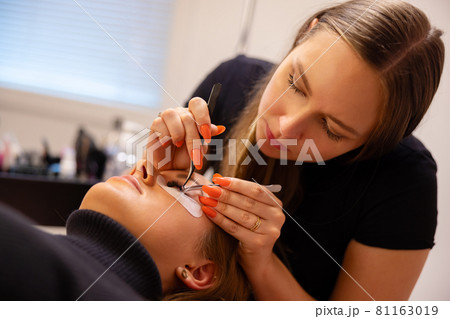 Beautician Using Tweezers For Eyelash Extension Treatment 81163019