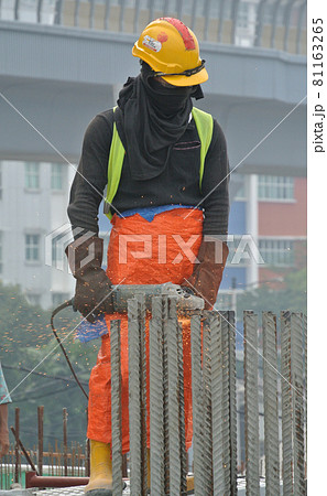 SELANGOR, MALAYSIA -AUGUST 29, 2016: Construction workers cutting reinforcement bar using mobile grinder at the construction site in Selangor, Malaysia. SELANGOR, MALAYSIA -AUGUST 29, 2016: Construction workers cutting reinforcement bar using mobile grinder at the construction site in Selangor, Malaysia. 81163265