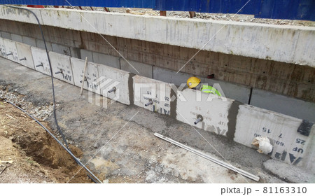 SELANGOR, MALAYSIA -OCTOBER 8, 2016: Construction workers installing precast concrete drain at the construction site. SELANGOR, MALAYSIA -OCTOBER 8, 2016: Construction workers installing precast concrete drain at the construction site. 81163310