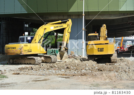 SELANGOR, MALAYSIA -AUGUST 08, 2016: Excavators machine is the heavy construction machine used excavate soil at the construction site. Powered by long hydraulic arm with bucket. Operate by workers. SELANGOR, MALAYSIA -AUGUST 08, 2016: Excavators machine is the heavy construction machine used excavate soil at the construction site. Powered by long hydraulic arm with bucket. Operate by workers. 81163430
