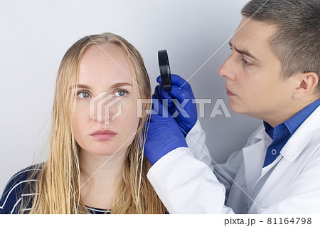 A trichologist examines a girl with oily hair. Problematic scalp and increased secretion of the sebaceous glands. Hair care. Oily hair care and treatment concept. Doctor prescribes treatment. A trichologist examines a girl with oily hair. Problematic scalp and increased secretion of the sebaceous glands. Hair care. Oily hair care and treatment concept. Doctor prescribes treatment. 81164798
