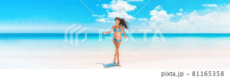 Beach Asian woman with fit summer bikini body happy running enjoying Caribbean vacation laughing of joy in tropical destination banner panorama. Blue swimwear model enjoying summer holidays. Beach Asian woman with fit summer bikini body happy running enjoying Caribbean vacation laughing of joy in tropical destination banner panorama. Blue swimwear model enjoying summer holidays. 81165358