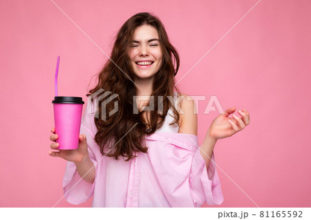 Beautiful young positive brunette woman wearing casual stylish clothes isolated over colorful 81165592
