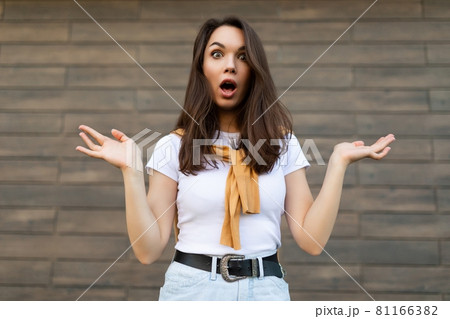 Photo of young emotional shocked astonished beautiful brunette woman wearing casual clothes standing 81166382