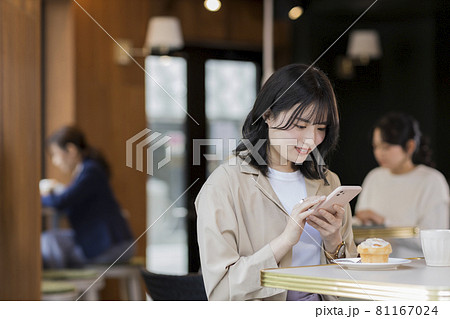 カフェでスマホを操作する若い女性 カフェでスマホを操作する若い女性 81167024