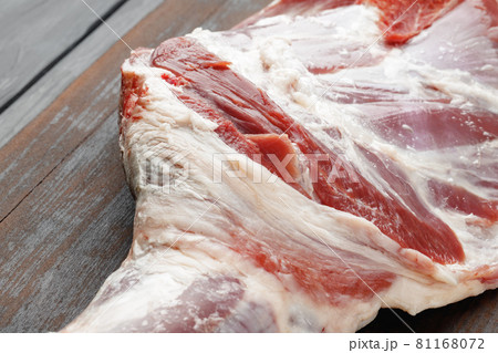 Raw beef leg on brown wooden board Raw beef leg on brown wooden board 81168072