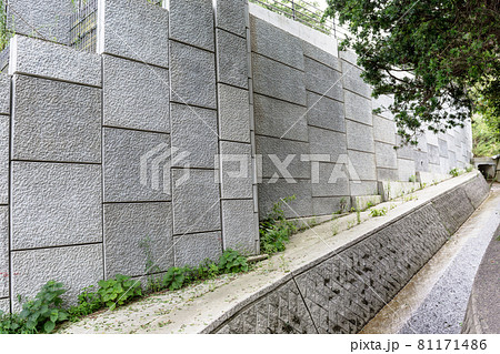 道路沿いに建設された新しいコンクリートの擁壁 81171486