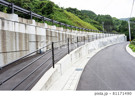 道路沿いに建設された新しいコンクリートの擁壁 81171490