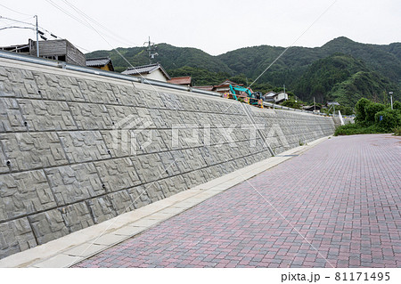 道路沿いに建設された新しいコンクリートの擁壁 道路沿いに建設された新しいコンクリートの擁壁 81171495