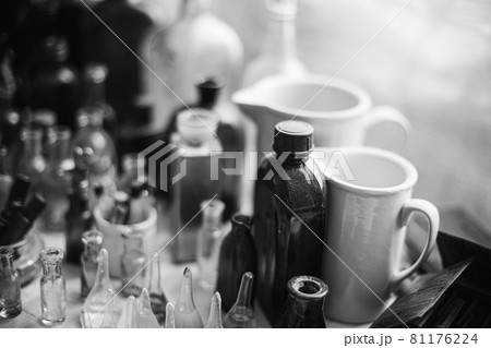 Many Old Deutsch Vintage Medical Glass Capacity. Detail Of Retro Chemical Pharmaceutical Science Researches. Small Bottles Different Sizes From Times Of World War II. WW2 WWII. Black And White 81176224