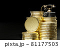 Vintage telephone set on top of stacked gold coins in a dark black background. The concept of business communication or the concept of business in telecommunication. 81177503