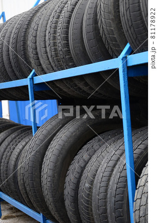 Rack with variety of car tires in automobile store. Many black tires. Tire stack background. Selective focus 81178922