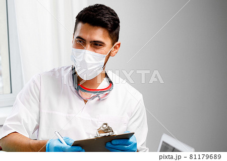 Mixed race male doctor sitting at his working table in hospital 81179689