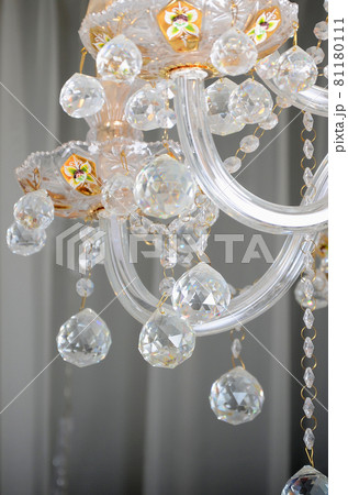 Close-up photo of the scenery on the old chandelier. Glass figures shine and reflect light with their faces 81180111