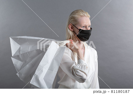 white caucasian albino blond woman holds black shopping bags. Sale and discounts on market and Black Friday concept. 81180187