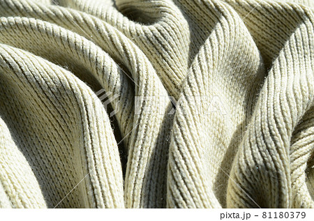 Fabric texture of a soft yellow knitted sweater. Macro image of the structure of bindings in yarns Fabric texture of a soft yellow knitted sweater. Macro image of the structure of bindings in yarns 81180379