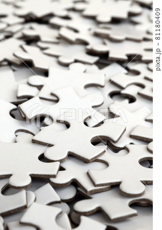 Close-up of a pile of uncompleted elements of a white puzzle. A huge number of rectangular pieces from one large white mosaic Close-up of a pile of uncompleted elements of a white puzzle. A huge number of rectangular pieces from one large white mosaic 81180409