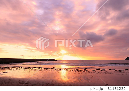 海に沈む夕陽が作る幻想的な夕焼け空の写真素材