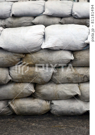 Background of many dirty sand bags for flood defense. Protective sandbag barricade for military use. Handsome tactical bunker 81181494