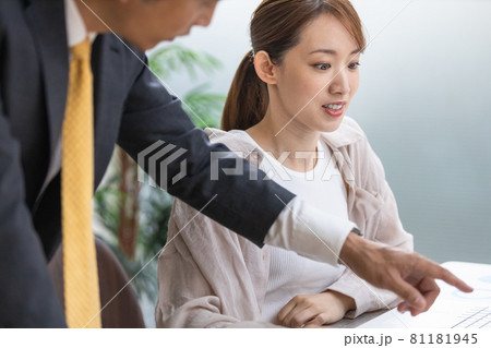 上司からのアドバイスを聞いている若い女性 81181945