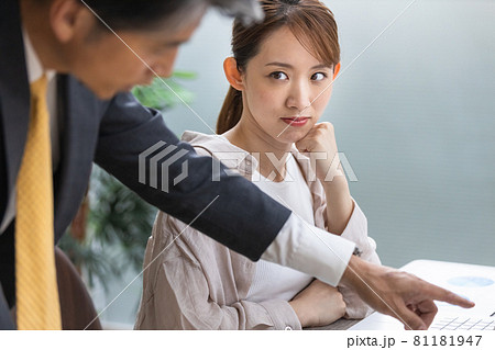 上司からのアドバイスを聞いている若い女性 81181947