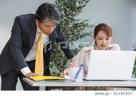 上司からのアドバイスを聞いている若い女性 81181957