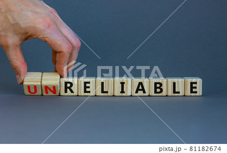 Unreliable or reliable symbol. Businessman turns wooden cubes and changes the word unreliable to reliable. Beautiful grey background, copy space. Business and unreliable or reliable concept. Unreliable or reliable symbol. Businessman turns wooden cubes and changes the word unreliable to reliable. Beautiful grey background, copy space. Business and unreliable or reliable concept. 81182674