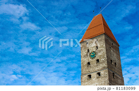 Old stone tower with clock and cupola seen from below against blue sky. Beautiful blue background, copy space. Old stone tower with clock and cupola seen from below against blue sky. Beautiful blue background, copy space. 81183099