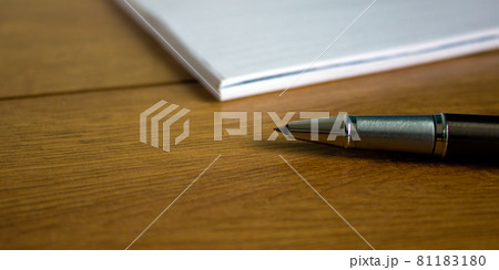 White notebook and pen on wood table. Business concept. White notebook and pen on wood table. Business concept. 81183180