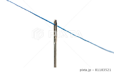 Stretched blue thread through the eye of a needle over a white background. 81183521