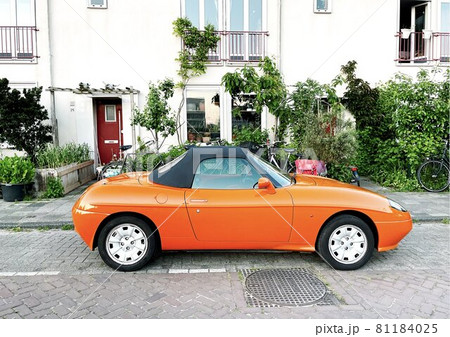 orange sports car convirtable parked in amsterdam orange sports car convirtable parked in amsterdam 81184025