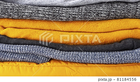 Pile of the grey and yellow warm knitted sweaters and jumpers close up Pile of the grey and yellow warm knitted sweaters and jumpers close up 81184556