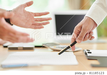 意見が食い違う若い男性と高齢の男性の手元 81185123