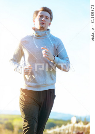 Man jogging in rural nature at beautiful summer day. Sport fitness model caucasian ethnicity training outdoor. Man jogging in rural nature at beautiful summer day. Sport fitness model caucasian ethnicity training outdoor. 81189373