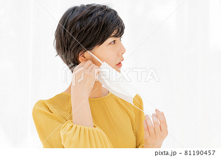 白いカーテンの前でマスクによる肌荒れに悩む若い女性 白いカーテンの前でマスクによる肌荒れに悩む若い女性 81190457